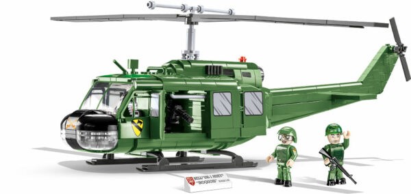 A green Bell UH-1 Huey 650 KL #2423 helicopter with two soldiers.