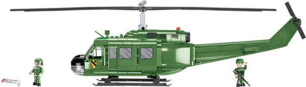 A green Bell UH-1 Huey 650 KL #2423 helicopter with two soldiers standing next to it.