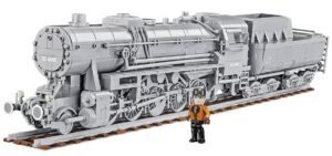 A model train of a Kriegslokomotive Baureihe 52 #6281 with a person standing beside it.