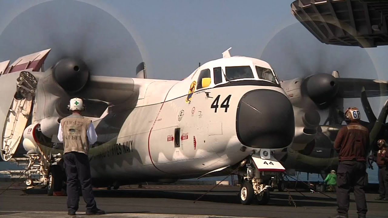 U.S. Navy C-2 Greyhound aircraft with flight deck crew during operations aboard the USS Enterprise aircraft carrier. Top Gun movie